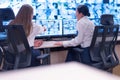 Security guard monitoring modern CCTV cameras in surveillance room. Two Female security guards in surveillance room