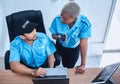 Security guard, safety officer and team in office with a laptop and walkie talkie for surveillance. Man and black woman Royalty Free Stock Photo