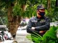 Security guard with surgical mask guarding motorbikes in Vietnam