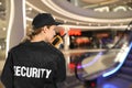 Security guard using portable radio transmitter in modern shopping mall