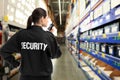 Security guard using portable radio transmitter in shopping mall