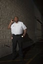 Security Guard Using Walkie Talkie While Patrolling At Night Royalty Free Stock Photo