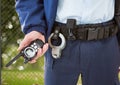 security guard with walkie-talkie on his hand and cuffs on the belt in front of the fence Royalty Free Stock Photo