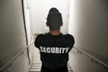 Security guy with a black hat and a uniform walking down the stairs inside a building Royalty Free Stock Photo