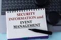 SECURITY INFORMATION and EVENT MANAGEMENT - words on a white sheet on the background of a computer keyboard and headphones Royalty Free Stock Photo
