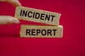 Security and insurance concept. Brick blocks with the inscription - Incident report on beautiful red background. Businessman hand