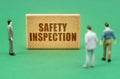 On the green surface are figures of people and a sign with the inscription - Safety Inspection Royalty Free Stock Photo