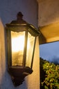 Security lantern seen outside and large house and garage.