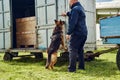 Security officer and drug detection dog checking cargo at aerodrome