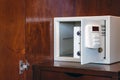 Security open metal safe with empty space inside in a wooden shelf. White safe box open door. Safe box with electronic lock in the Royalty Free Stock Photo