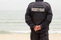 Security police man with clasped hands guarding on the coastline