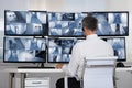 Security System Operator Looking At CCTV Footage At Desk Royalty Free Stock Photo