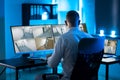 Security System Operator Looking At CCTV Footage At Desk Royalty Free Stock Photo