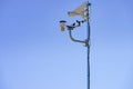 Security video camera and wind indicator against sky Royalty Free Stock Photo