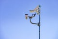Security video camera and wind indicator against sky Royalty Free Stock Photo