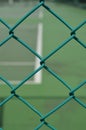 Security wire mesh fence with blurred tennis court background Royalty Free Stock Photo