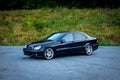 Sedan luxury black car parked in the parking lot near a forest-profile photo