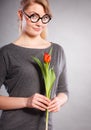 Seducive nerdy girl holding tulip. Royalty Free Stock Photo