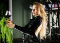 Seductive blonde in a green evening dress posing with a glass of red wine Royalty Free Stock Photo