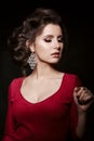 Seductive brunette wearing red dress and big earrings. Royalty Free Stock Photo