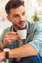 Seductive casual man takes a coffee break and looks to side Royalty Free Stock Photo