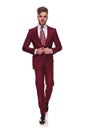 Seductive elegant man stepping forward and buttoning grena suit