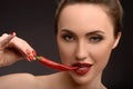 Seductive girl eating spicy red pepper Royalty Free Stock Photo