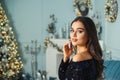 Seductive girl with fashion makeup and hairstyle posing at luxury christmas interior. Woman in fashion dress with sparkles Royalty Free Stock Photo