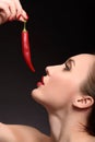 Seductive girl flirting with spicy pepper Royalty Free Stock Photo