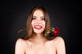Seductive sensual woman holding red rose with teeth. Woman with naked shoulder and rose flower in mouth on black Royalty Free Stock Photo