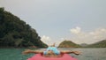 Seductive woman lifts up long legs lying on canoe on sea Royalty Free Stock Photo