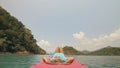 Seductive woman lifts up long legs lying on canoe on sea Royalty Free Stock Photo