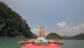 Seductive woman lifts up long legs lying on canoe on sea Royalty Free Stock Photo