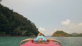 Seductive woman lifts up long legs lying on canoe on sea Royalty Free Stock Photo