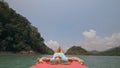 Seductive woman lifts up long legs lying on canoe on sea Royalty Free Stock Photo