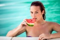 Seductive woman in pool refreshes with piece of watermelon Royalty Free Stock Photo