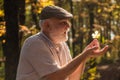 See beauty in simple things. Curiosity to botany. Explore world around. Pensioner hiking in forest on sunny autumn day