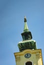 Looking up at a blue sky and a church steeple with cross in Budapest, Hungary.