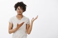 See I told you. Portrait of confident and pleased cute male model with tanned skin and afro haircut, showing something