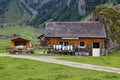 19.08.2021 Seealpsse switzerland: alpine cheese dairy farm built in old style next to a rock wall empty milk cans in front of the Royalty Free Stock Photo