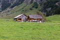 19.08.2021 Seealpsse Switzerland: old style alpine dairy built next to a rock wall, empty milk cans in front of the house, german Royalty Free Stock Photo