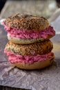Pink strawberry cream cheese filled seeded bagel sandwiches stack