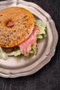 Seeded bagel with steak on tin plate