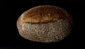 Seeded loaf of bread on black background