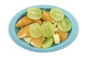 Seedless grapes orange kiwi apples cut in pieces in blue oval sh Royalty Free Stock Photo