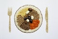 Seeds art: healthy vegetarian food in a plate with fork and knife besides
