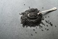 Seeds of black sesame seeds on a dark background of stone, a silver spoon. Close-up Royalty Free Stock Photo