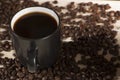 Seeds of coffee in a black cup on a wooden background Royalty Free Stock Photo