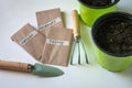 Seeds of herbals in paper bags, garden tools for home. green plastic pots. Planting on balcony, during quarantine. Close up