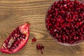 A bowel of pomegranate seeds beside a piece of pomegranate fruit Royalty Free Stock Photo